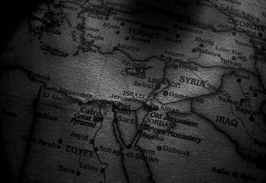Close-up grayscale image of a map showing countries in the Middle East, including Egypt, Syria, and Iraq.
